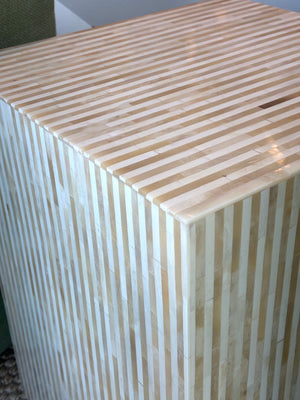 A close-up of the Bojay Stripe Side Table, featuring alternating light and dark beige horizontal stripes that emphasize its artisanal craftsmanship.