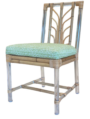 The Sea Cliff Side Chair, Amala Vert by Associated Design features an acrylic and bamboo frame, a custom green Amala Ikat seat cushion, and clear plastic protective leg covers.