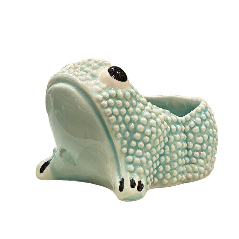 The Jean Roger Paris Ceramic Frog Collection features light blue ceramic planters with textured skin and a hollow back, inspired by the brand’s iconic frog designs.