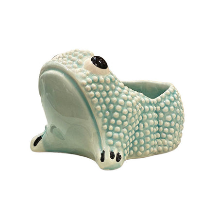 The Jean Roger Paris Ceramic Frog Collection features light blue ceramic planters with textured skin and a hollow back, inspired by the brand’s iconic frog designs.