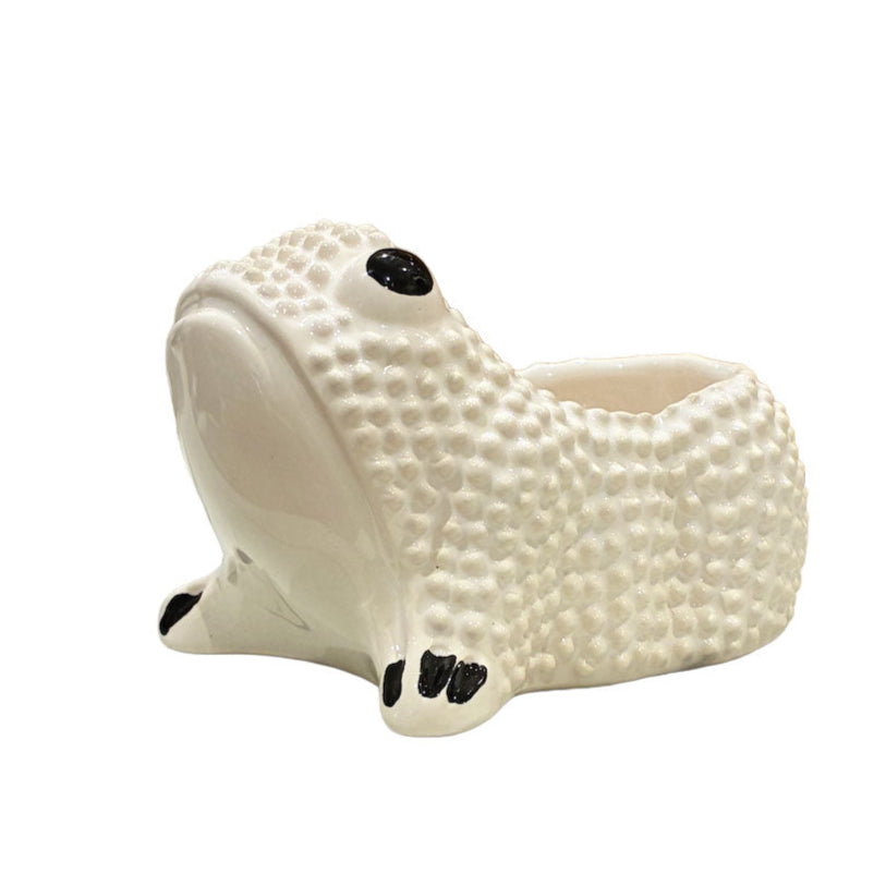 From the Ceramic Frog Collection by Jean Roger Paris, this white ceramic frog planter features a textured surface, black eye and toe details, and a back opening for displaying a small plant.