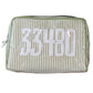 The Walker Valentine Milan Cosmetic Case features green and white vertical stripes with "33480" stitched in large white numbers—a stylish choice for travel.