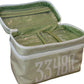 A green and white striped Walton Travel Case by Walker Valentine, featuring the number 33480 on the front and a secure double zipper, sits open on a wicker surface.
