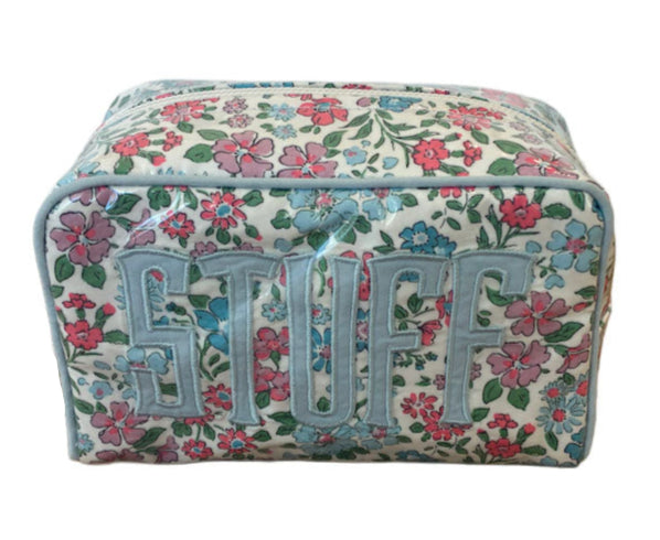 The Milan Cosmetic Case by Walker Valentine is a rectangular beauty essentials organizer featuring a floral pattern and the word "STUFF" in large letters on the front.