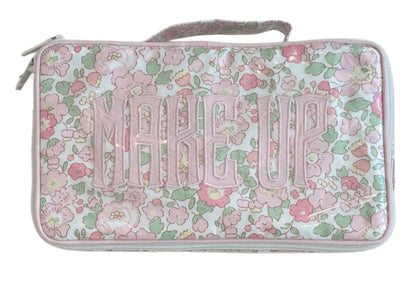 The Walker Valentine Handled Brush and Makeup Case is a rectangular bag with a floral pink, green, and white pattern and "MAKE UP" on the front—ideal as a travel case for organizing brushes and essentials.