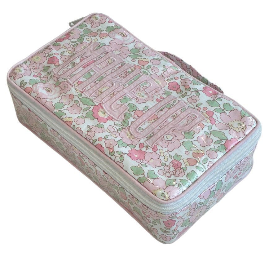 The Walker Valentine Handled Brush and Makeup Case is a rectangular floral travel case with handle and zipper, "MAKEUP" embroidered on the lid, and brush compartments for organized storage.