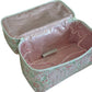 The Walton Travel Case by Walker Valentine, a rectangular floral fabric organizer with a pink interior, is open to show inner pockets and a lighter inside.