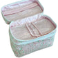 The Walton Travel Case by Walker Valentine is a pastel floral makeup bag with "MAKEUP" on the front, featuring multiple clear compartments inside—ideal for organizing your beauty essentials while traveling.