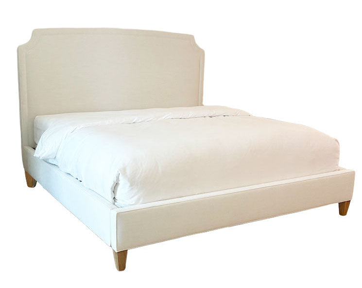 The Lee Industries Laguna Cloud Cut Corner King Bed features a high headboard, light wooden legs, and white bedding in luxurious Laguna Cloud fabric, creating contemporary elegance against a plain white background.