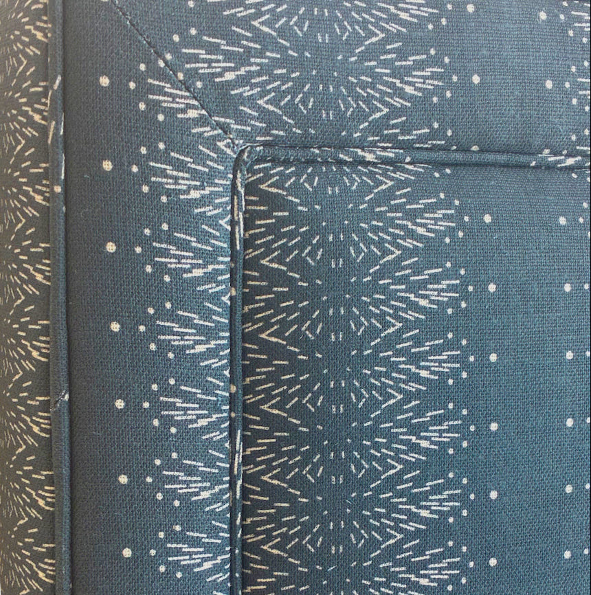 Close-up of Sorrento Navy Square Queen Bed by Lee Industries, showcasing navy upholstery with white geometric starburst stitching and visible seam lines.