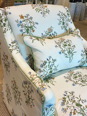 The Bowen Arm Chair in Flax & Field Flowers by Bunny Williams is an upholstered armchair with a matching pillow, both featuring a floral print on a light background and finished with elegant slipcover upholstery.