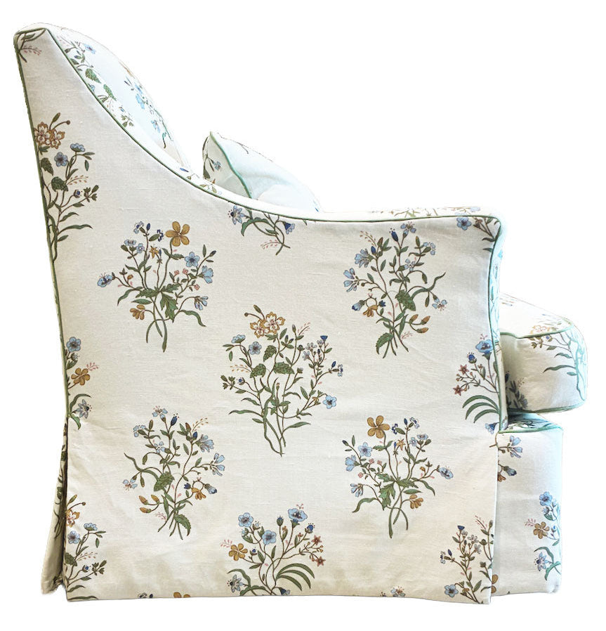 Side view of the Bunny Williams Bowen Arm Chair in Flax & Field Flowers, featuring slipcover upholstery with green stems and blue, yellow, and brown flowers on a white background.