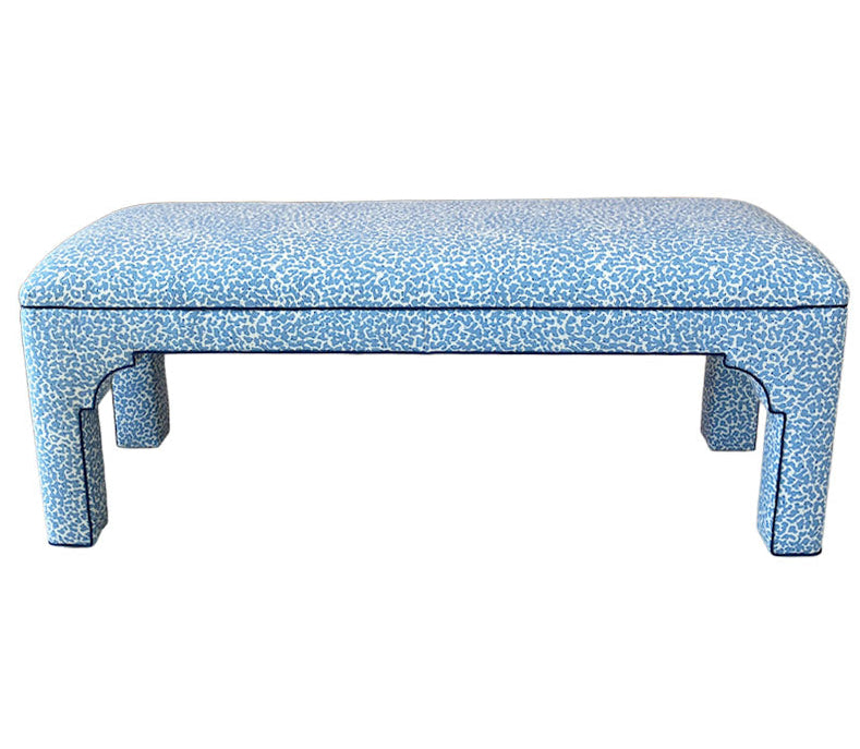 The Taj Bench by Bunny Williams features a sturdy maple frame, four legs, and light blue upholstery with a subtle white speckled pattern.