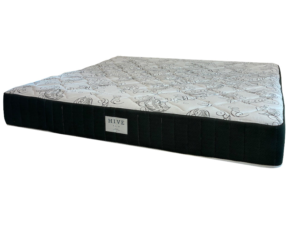 The EJ Schrader Hive Custom Palm Mattress, queen size, has a patterned white top, black sides, and a "HIVE" label on the front. Designed for side sleepers, it features cooling gel foam for added comfort.
