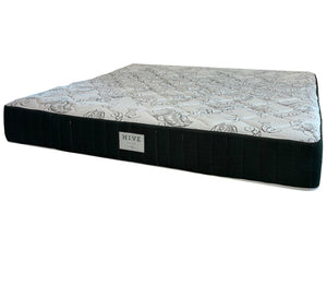 The EJ Schrader Hive Custom Palm Mattress, queen size, has a patterned white top, black sides, and a "HIVE" label on the front. Designed for side sleepers, it features cooling gel foam for added comfort.