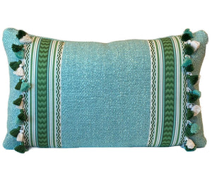 The Pyla Lagon Pillow by Hive Custom Pillows features a rectangular teal design with green and white stripes, side tassels, and is crafted from premium materials for a luxurious accent.