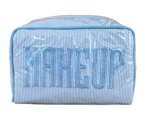 The Walker Valentine Small Milan Cosmetic Case features blue and white stripes and "MAKEUP" embroidered on the front—ideal for organizing your beauty essentials while traveling.