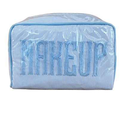 The Walker Valentine Small Milan Cosmetic Case features blue and white stripes and "MAKEUP" embroidered on the front—ideal for organizing your beauty essentials while traveling.
