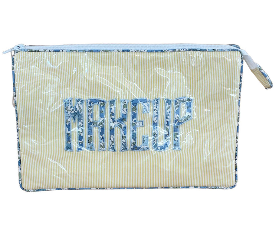 The Walker Valentine Large Helen Cosmetic Case features a rectangular shape, zipper closure, vertical stripes, and "MAKEUP" in blue patterned letters on the front—perfect for organizing your beauty essentials.