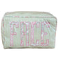 The Walker Valentine Large Milan Cosmetic Case, "FACE," is a rectangular striped travel makeup bag with a floral pattern and bold pink lettering—ideal as a beauty organizer for your essentials.
