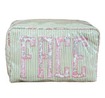 The Walker Valentine Large Milan Cosmetic Case, "FACE," is a rectangular striped travel makeup bag with a floral pattern and bold pink lettering—ideal as a beauty organizer for your essentials.