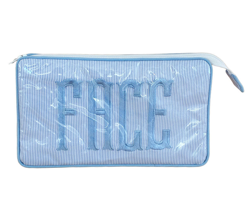 The Walker Valentine Small Helen Cosmetic Case, "FACE," is a blue and white striped zippered makeup bag with bold embroidered letters under a clear cover—perfect for organizing your essentials.