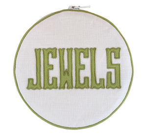The Walker Valentine Jewelry Roll, "JEWELS," features bold green embroidery on white fabric—a stylish and practical accent for organizing or traveling with your jewelry.
