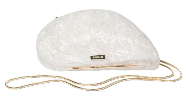 Simkhai Bridget Oyster Shell Clutch with a gold chain shoulder strap and designer label.
