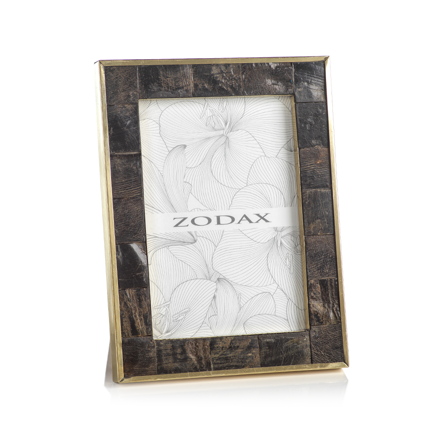 A rectangular frame from Zodax’s Natural Horn with Brass Trim Frame Collection features a dark, textured horn border, unique patterns, elegant brass trim, and a Zodax floral line art insert.
