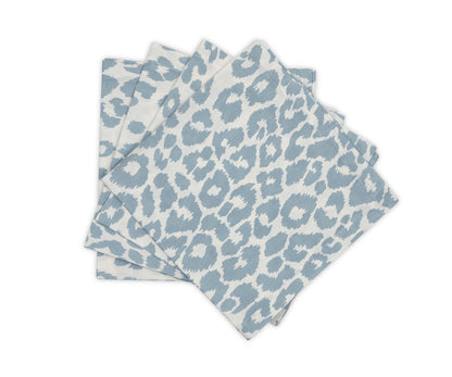 Four blue and white napkins from Matouk's Iconic Leopard Sky Tabletop Collection are stacked on a white background, bringing a bold accent to your classic table linens.