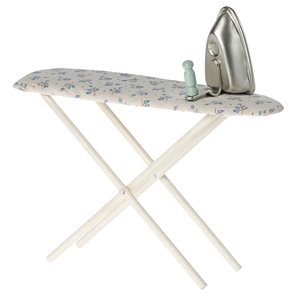 The Maileg Iron & Ironing Board, Miniature, featuring crossed white legs and a blue floral fabric, sits ready for use—a perfect addition to any dollhouse setup.