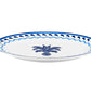 A white porcelain plate featuring a blue patterned rim and central blue palm tree, reminiscent of the Jaipur Blue Oval Platter by Aquazzura Casa.