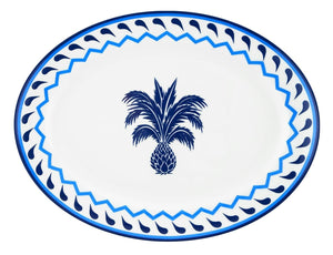 The Aquazzura Casa Jaipur Blue Oval Platter is a round white porcelain plate featuring a central blue pineapple and a blue geometric border, inspired by Jaipur motifs—an elegant addition to any table setting.