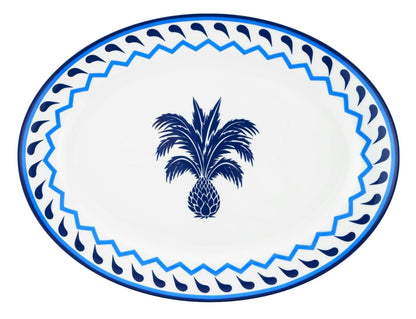 The Aquazzura Casa Jaipur Blue Oval Platter is a round white porcelain plate featuring a central blue pineapple and a blue geometric border, inspired by Jaipur motifs—an elegant addition to any table setting.