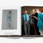 An open book from Assouline, titled "James Bond Style," reveals a sketch of a woman in a blue dress on the left page, capturing timeless fashion. On the right page, a photo showcases three people interacting in formal and feathered attire, evoking iconic James Bond-style looks.