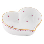 The Herend Heart Bowl is a white porcelain bowl shaped like a heart, adorned with hand-painted small pink hearts and finished with a gold-edged rim.