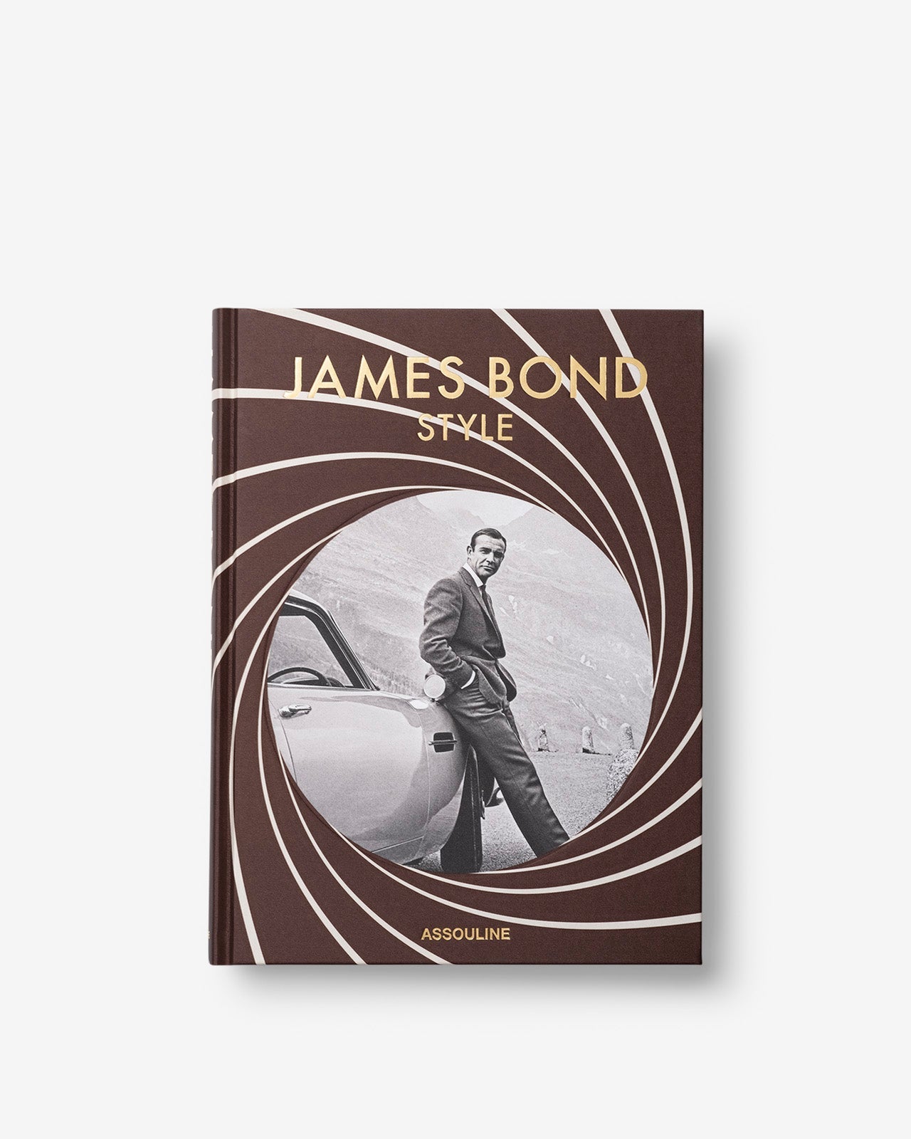 The "James Bond Trilogy with Slipcase" by Assouline features stylish cover art of a man with a car and spiral design. A perfect collector’s piece for James Bond fans and an ideal addition to any coffee table book collection.