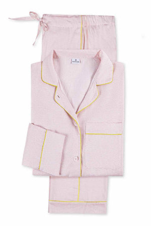 The Matouk Jasper Pajama Set features light pink cotton sateen with yellow piping, including a button-up long-sleeve top and drawstring pants.