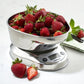 A Cuisinart PrecisionChef Bowl Digital Kitchen Scale with a stainless steel bowl of fresh strawberries rests on a white surface, next to a green-striped cloth.