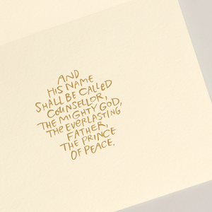 The Away In A Manger Card Set by Crane features a handwritten Bible verse: "And his name shall be called Counsellor, The Mighty God, The Everlasting Father, The Prince of Peace," ideal for a heartfelt Christmas card.
