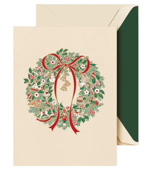The Crane Christmas Morning Wreath Card Set features cream-colored cards with a festive wreath of ornaments, candy, and a red bow, paired with matching envelopes lined in green.