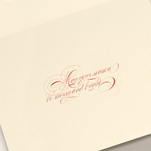 The Crane Sleigh Holiday Card Set features cream-colored cards with red calligraphy reading "May your season be merry and bright" and includes coordinating envelopes—perfect for festive greetings.