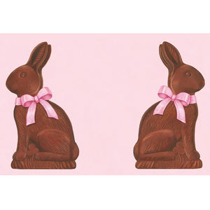 Two Hershey's Chocolate Bunny Place Setting Collection figurines by Hester & Cook, each with a pink bow, are displayed on a light pink background—perfect for celebrating Easter.