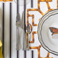 A fork, knife, and spoon rest on a Hester & Cook Die-cut Bamboo Placemat Collection mat beside a plate featuring a butterfly place card—an elegant detail for festive table decor.