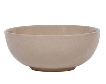 The Juliska Puro Taupe Dinnerware Collection features a round, beige ceramic bowl with smooth sides and a slightly raised base in a versatile taupe hue, ideal for stylish table settings. Shown against a white background.