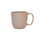 The Juliska Puro Taupe Dinnerware Collection features a plain beige ceramic mug with a handle, shown against a white background—ideal for elegant table settings and timeless style.