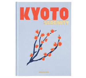 The "Kyoto Serenity" book by Assouline features a cover with stylized red and orange flowers on a light blue background, celebrating Japanese culture and evoking the vibrant Gion Matsuri festival.