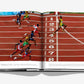 An open book titled "The Last Heroes: 100 Moments of Olympics Legend" by Assouline displays a photograph capturing the dramatic close finish of a track race at the Olympic Games, with multiple runners crossing the finish line.