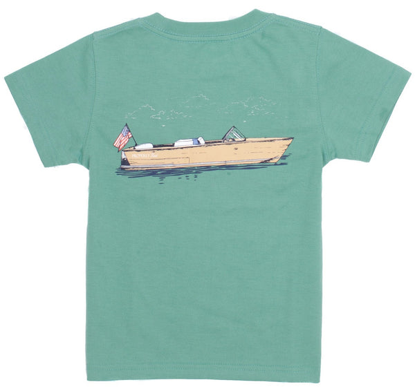 A Properly Tied Boating Tradition Tee featuring a graphic print of a boat on water, with an American flag at the stern.