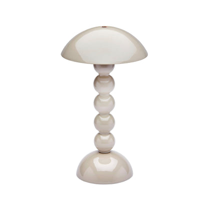The Addison Ross Bobbin LED Cordless Lamp features a modern beige bobbin shape with a dome shade and four stacked glossy spheres. It offers adjustable light levels for versatile, portable lighting.